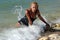 Wet blond kneeling in surf