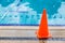 wet bright orange cone placed by the swimming pool side as safety precaution sign