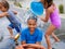 Wet Brother and Sisters Playing Outside with Water