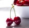 Wet cherry berry on the white bowl macro background two shaddow fresh