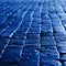Wet cobblestones with blue reflected light at night