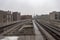 Wet empty elevated subway tracks on overcast day
