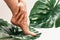 Wet female feet with smooth skin and Monstera deliciosa tropical leaf