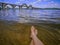 Wet female feet in the water against the background of a blurred landscape with the Merefa-Kherson bridge in Dnipro Ukraine.
