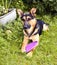 Wet German shepherd lying with his dog toy in the grass after showering