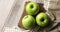 Wet green apples on canvas