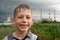 Wet and happy child smiling outdoors on the industrial background with corn field and power station