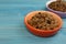 Wet pet food in feeding bowl on light blue wooden table. Space for text