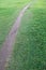 Wet after rain straight narrow path for cyclists and pedestrians in the field, background