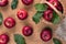 Wet red apples with green leaves in basket and on sacking material