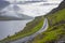 Wet road bordering a lake in the Faroe Islands