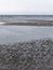 Wet sand on the shore, low tide. Gloomy seaside landscape. The harsh nature of the north of Europe. The cold coast of the Atlantic