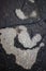 Wet spots on the dark asphalt in the form of a cartoon Batman head