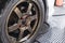 A wet tire and rim of a sedan still with soap suds after a through cleaning. At a carwash