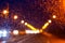 Wet track at night with the prospect of lighting lights along the road on a rainy night, blurred background