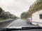 Wet windscreen from rain overtaking car towing a caravan.