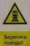 Wet yellow warning sign for trains passing nearby