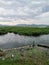 Wetland waterway grass mountains dark clouds