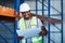 Weve got another shipment coming in. a handsome young contractor standing in the warehouse and reading paperwork.