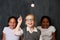 Weve got the solution. Portrait of three primary shool students below a lightbulb in class.