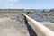 Whakatane heads beach and waterfront with logs and driftwood washed up across beach and outlook to horizon and Whale Island