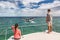 Whale watching boat tour tourists people on ship looking at humpback tail breaching ocean in tropical destination, summer travel