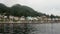 Wharf for boats on calm water of Pacific Ocean on background coast in Alaska.