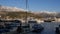 Wharf with moored boats against the background of mountains in the snow