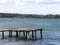 Wharf Pier Catwalk on Lake with Clouds on Sky in Background