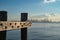 Wharf piles and beams at end of dock with CBD skyline of Melbourne in background across harbour