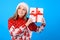 What can be there? Close up portrait of excited joyful happy woman with a present box, isolated on blue background