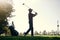 What a day for golfing. a focused young male golfer about to swing and play a shot with his golf club outside on a