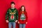 What disgust. Portrait of frustrated two brunette haired students stare at deer christmas tree design jumper displeased