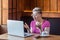 What do you want? Side view portrait of shocked young businesswoman in pink t-shirt is sitting in cafe, reading news and remotely