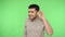 What? I cant hear you! Deaf confused brunette man keeping arm near ear and trying to listen talk. green background, chroma key