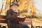 What lifestyle sense. Profile side photo of pensive old man rest relax in fall nature october trees park read book