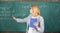 What makes great teacher. Teacher smart woman with book explain topic near chalkboard. School teacher explain things