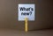 What is new symbol. White paper with words `Whats New`, clip on wood clothespin. Beautiful grey background. Business and what is