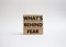 What\\\'s behind fear symbol. Concept words Whats behind fear on wooden blocks. Beautiful white background. Business and Whats