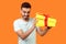 What`s in the box. Portrait of happy curious man looking inside gift box. indoor studio shot isolated on orange background