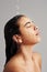 What a stimulating shower. Studio shot of a young woman enjoying a shower against a gray background.