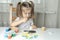 What to do for a child during the period of quarantine and self-isolation, a girl plays and paints on the table
