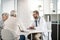 So what are your symptoms. a confident young male doctor consulting a mature patient inside of the doctors office.