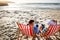 Whats more relaxing than this. a mature couple relaxing on beach chairs.