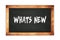 WHATS  NEW text written on wooden frame school blackboard