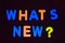 Whats new ? word written with different colored letter blocks on a dark background