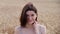 Wheat-2Portrait of beautiful young woman brunette looking up to the camera. Carefree caucasian girl with pretty smile in wheat