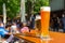 A wheat beer and a pils are standing on a table in a beer garden