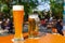 A wheat beer and a pils are standing on a table in a beer garden