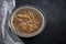 Wheat bran breakfast cereal with no milk in a bowl. Black background with homespun napkin